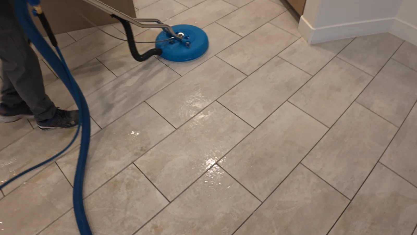 Tile and grout cleaning equipment working on a floor